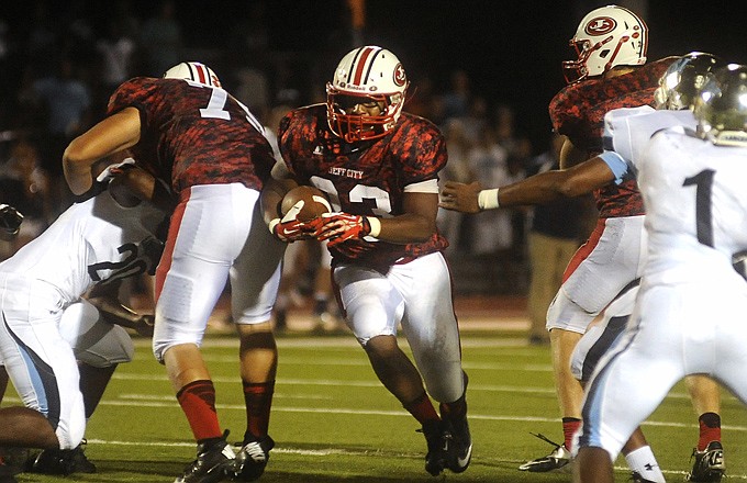 Jays running back Elijah Pittman breaks through a hole during Friday's game against Belleville (Ill.) East at Adkins Stadium.