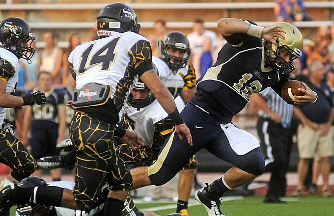 Helias quarterback Wyatt Porter runs through the Sedalia Smith-Cotton Tiger defense during Saturday's game at Adkins Stadium.