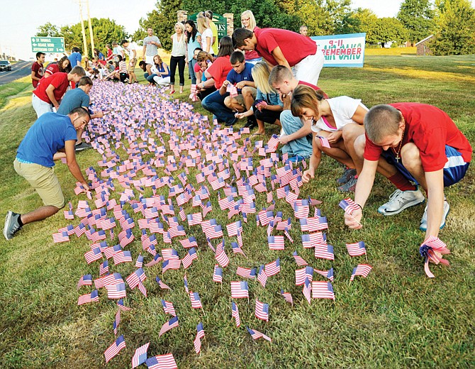Before the start of classes Wednesday morning, students from Blair Oaks High School stuck 2,976 miniature flags in the soil near Route M in front of the school. It took only a few minutes as numerous students participated in the remembrance activities on the 12th anniversary of the Sept. 11 attacks.