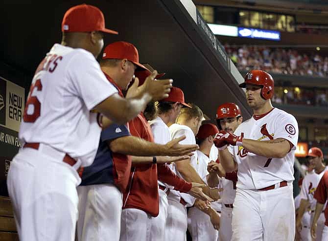 St. Louis Cardinals' Matt Holliday, right, is congratulated by teammates in the dugout after hitting a two-run home run during the sixth inning of a baseball game against the Milwaukee Brewers on Tuesday, Sept. 10, 2013, in St. Louis. 