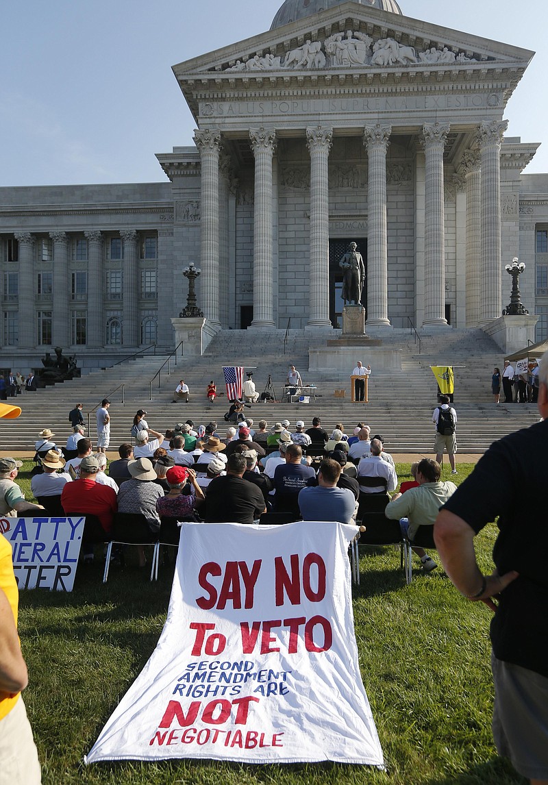 A sign to say "no the the veto" appears at a rally on the south lawn of the Missouri State Capital in Jefferson City, Mo., Wednesday, Sept. 11, 2013. The governor vetoed a bill that attempted to nullify certain federal gun laws. The rally is in support of an override of that veto. (AP Photo/Orlin Wagner)