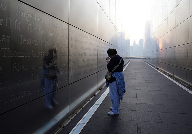 A person pauses Wednesday near a name on the wall of the "Empty Sky" memorial to New Jersey's victims of the 2001 terrorist attacks in Jersey City, N.J.