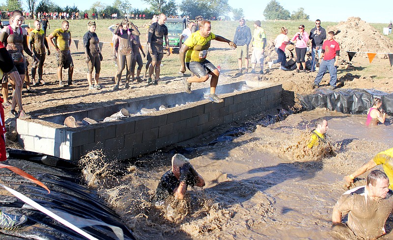 The "Mystery Obstacle" on the schedule turned out to the the Fire Walker. Tough Mudders ran toward the pool of mud, jumped over a pit filled with burning firewood and splashed into a deep pool of mud.