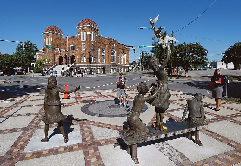 A newly unveiled statue honoring four slain young church girls graces the corner across the street from the 16th Street Baptist Church in Birmingham, Ala.