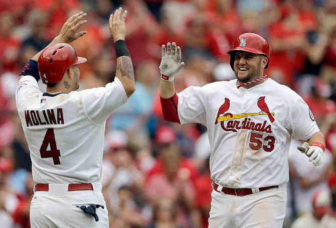 St. Louis Cardinals' Matt Adams, right, is congratulated by teammate Yadier Molina after hitting a two-run home run during the fifth inning of a baseball game against the Seattle Mariners Sunday, Sept. 15, 2013, in St. Louis.