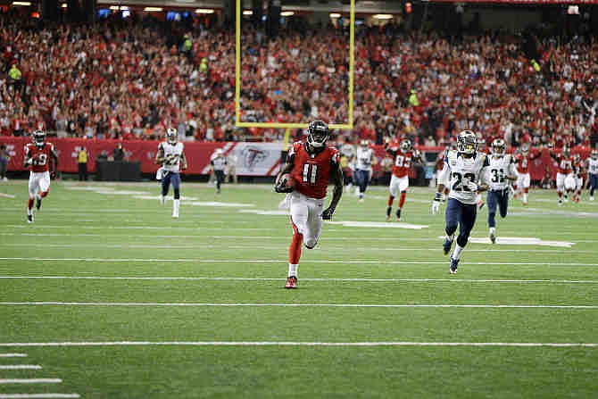 Atlanta Falcons wide receiver Julio Jones (11) makes a catch against the St. Louis Rams tried the tackle during the first half of an NFL football game, Sunday, Sept. 15, 2013, in Atlanta. Jones scored on the play.