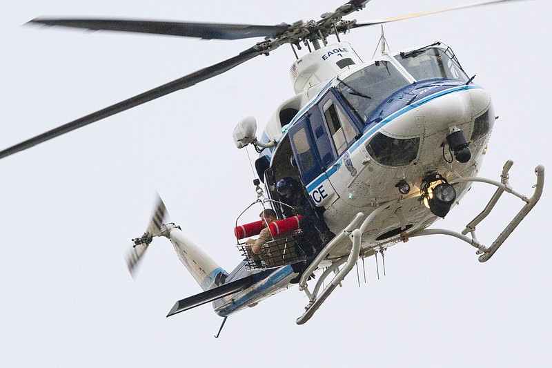 A U.S. Park Police helicopter removes a man in a basket from the Washington Navy Yard Monday, Sept. 16, 2013.    Earlier in the day, the U.S. Navy said it was searching for an active shooter at the Naval Sea Systems Command headquarters, where about 3,000 people work.  The exact number of people killed and the conditions of those wounded was not immediately known. 