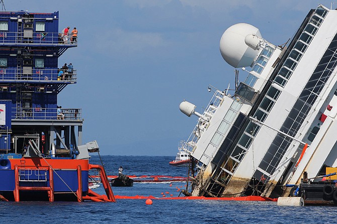 The Costa Concordia ship lies on its side Monday on the Tuscan Island of Giglio, Italy. Engineers succeeded in wresting the hull of the ship from the Italian reef where it has been stuck since it capsized in January 2012, leaving them cautiously optimistic they can rotate the luxury liner upright and eventually tow it away.