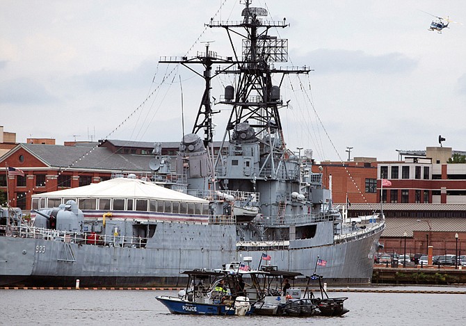 A Park Service helicopter flies overhead as two police boats take up station in the Washington Navy Yard after a gunman opened fire in a headquarters building.