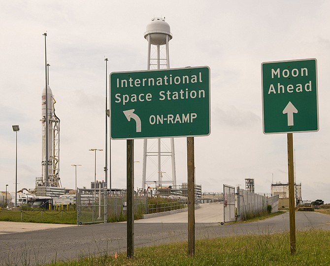Signs stand outside launch Pad-OA near the Orbital Sciences Corporation Antares rocket, left, with its Cygnus cargo spacecraft aboard, at the Mid-Atlantic Regional Spaceport (MARS) at the NASA Wallops Flight Facility in Wallops Island, Virginia.
