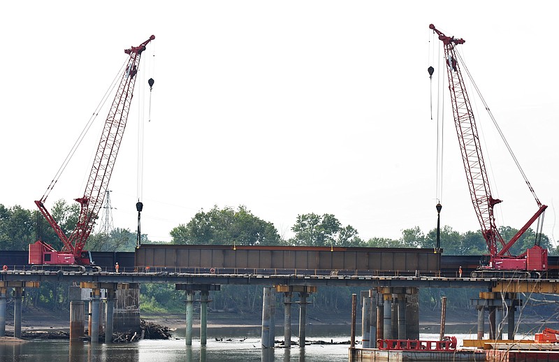 Heavy equipment is used to move a large steel girder into place on the Union Pacific railroad bridge under construction in Osage City, Mo. MoDOT officials said Tuesday that the Osage River project will be done at the end of the year as planned. 