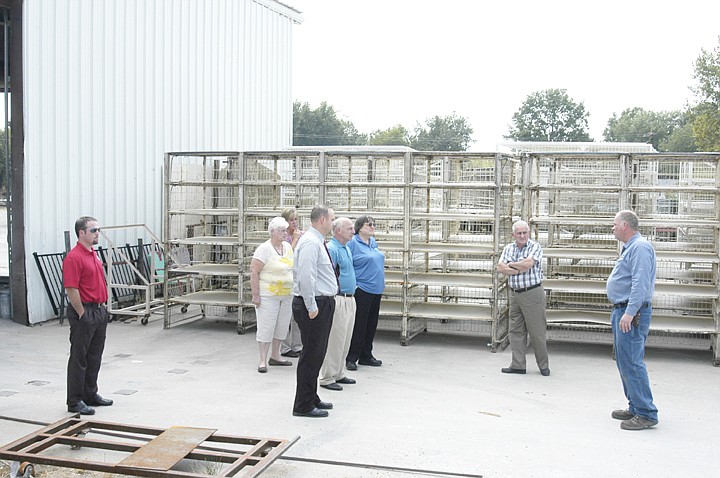 With a background of turkey coops, some new and some to be reburbished, Koechner Manufacturing President Mark Koechner, far right, speaks to members of the MRED Board of Directors during a tour of the Tipton facility. 