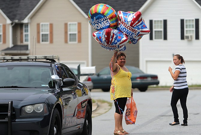 Well wishers with "Welcome Home" balloons head to 14-year-old Ayvani Hope Perez's family home in the Brookgate subdivision of Jonesboro, Ga. on Wednesday afternoon after police announced that she had been found.