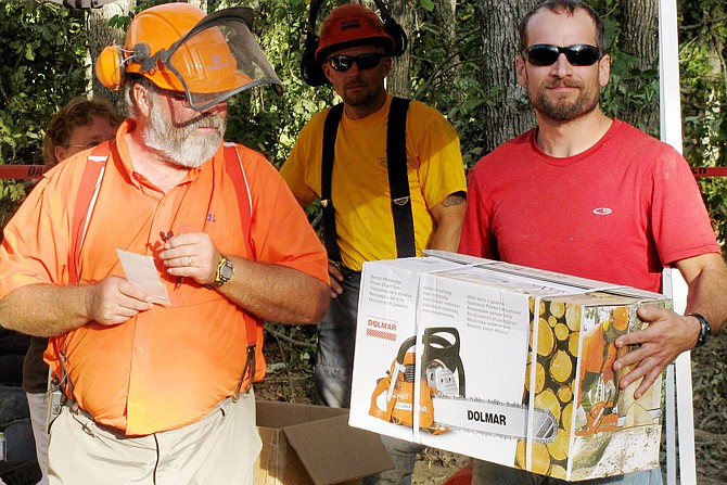 Josh Stevens of Fulton, right, won first place honors in the professional division in the 2013 "Game of Logging" statewide competiton at Viburnum. Wilth him is logging trainer Joe Glenn. Contestants were judged on various skills, including the precision tree felling event, where he hit the target. Stevens won $1,000 and a new chainsaw.                               