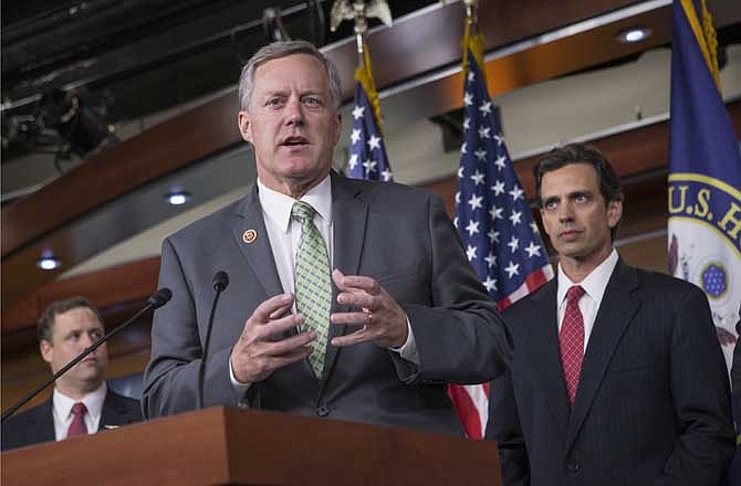 Rep. Mark Meadows, R-N.C, center, Rep. Tom Graves, R-Ga., right, and other conservative Republicans discuss their goal of obstructing the Affordable Care Act, popularly known as Obamacare, as part of a strategy to pass legislation to fund the government, on Capitol Hill in Washington, Thursday, Sept. 19, 2013.