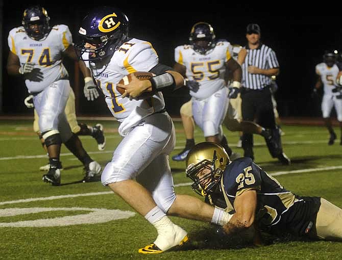 Helias linebacker Michael Tannehill grabs for Hickman's quarterback in Friday night's game at Adkins Stadium in Jefferson City.
