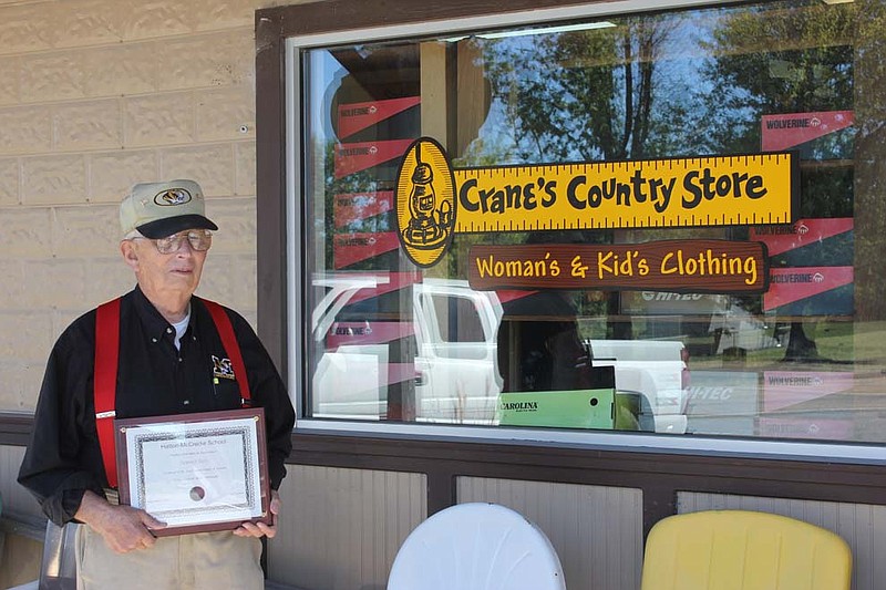 Joe Crane holds the certificate he received at the naming ceremony of Crane's Gym at Hatton-McCredie Elemetary School at his Williamsburg museum. The gym was named in his honor as the school's long-standing principal.