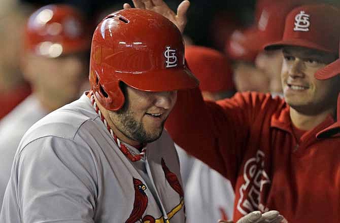 St. Louis Cardinals' Matt Adams is congratulated in the dugout after hitting a two-run home run against the Milwaukee Brewers in the first inning of a baseball game Saturday, Sept. 21, 2013, in Milwaukee.