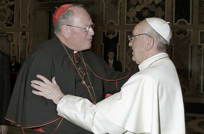  In this March 15, 2013 photo made available by the Vatican newspaper L'Osservatore Romano, Pope Francis is greeted by Cardinal Timothy Dolan as he meets the Cardinals for the first time after his election at the Vatican.
