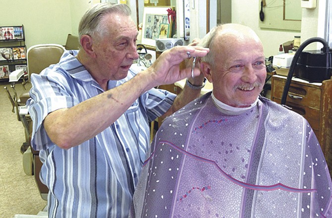 Larry Horstdaniel gets to work cutting longtime customer James Weber's hair Friday. Horstdaniel, 85, will celebrate 60 years in business today. Weber said he has been coming to Larry's Barber Shop for as long as he can remember. 