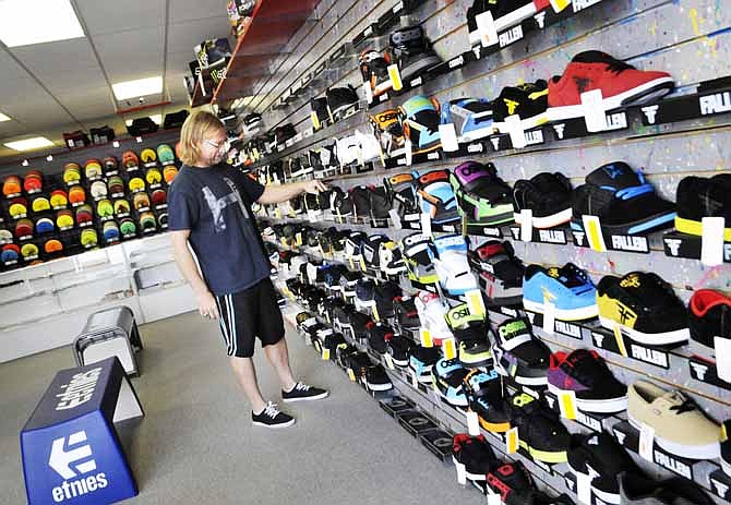 
Bob Wieger straightens the shoes on display at his newly opened store at 744 W. Stadium Blvd. He recently moved here from Mitchell, S.D., and is working to have a successful shop in Jefferson City.