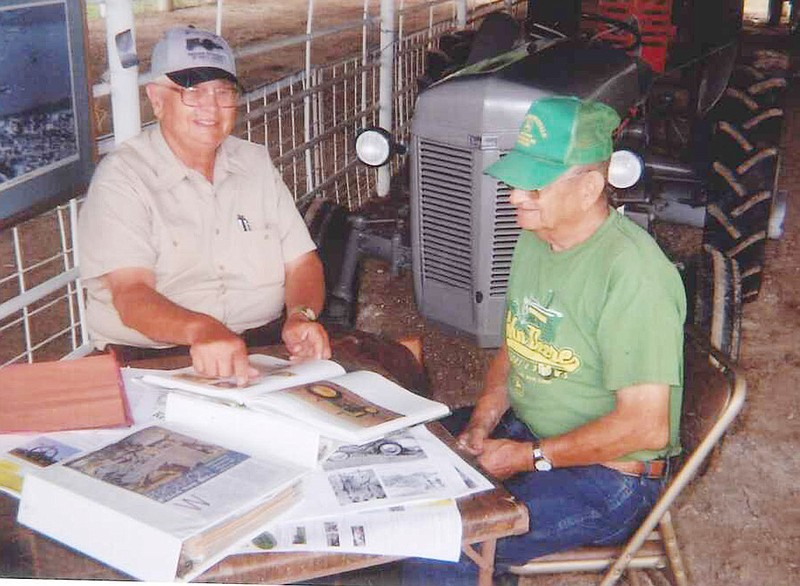 Rodney Garnett of Holts Summit, left, a tractor buff and former John Deere dealer, discusses John Deere tractors with Benson Lehman during this year's Callaway County Fair. The tractor beside them is Garnett's 1947 Ferguson TE-20 manufactured in England. 