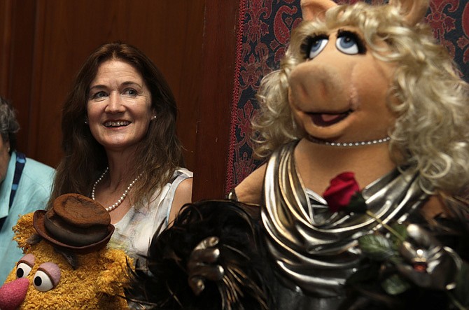 Cheryl Henson, left, daughter of Jim Henson, looks at a Muppet of Miss Piggy after a ceremony to donate additional Jim Henson objects to the Smithsonian's National Museum of American History, in Washington, on Tuesday.