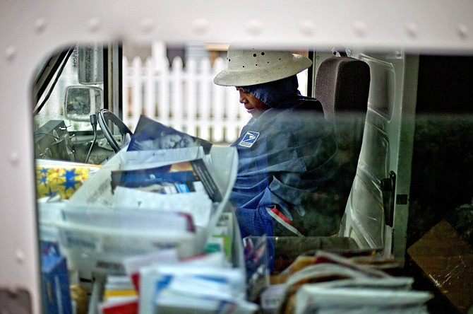 U.S. Postal Service letter carrier Jamesa Euler, delivers mail Feb. 7 in Atlanta. The financially struggling Postal Service said Wednesday, it is seeking a 3-cent increase in the cost of mailing a letter, bringing the price of a first-class stamp to 49 cents. 