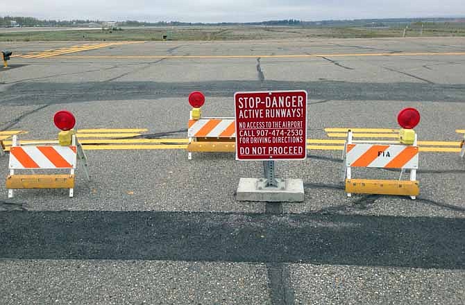 This Sept. 20, 2013 image provided by the Fairbanks International Airport shows the barricaded entrance to a taxiway, at Float Pond Road blocking access to Taxiway B in Fairbanks, Alaska. A glitch in the Apple Maps app on newer iPhones and iPads guides people up to this runway at Fairbanks International Airport instead of the proper route to the terminal. 