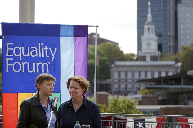 Plaintiffs Isabelle Barker, left, and her spouse Cara Palladino speak during a news conference Thursday near Independence Hall in Philadelphia. 