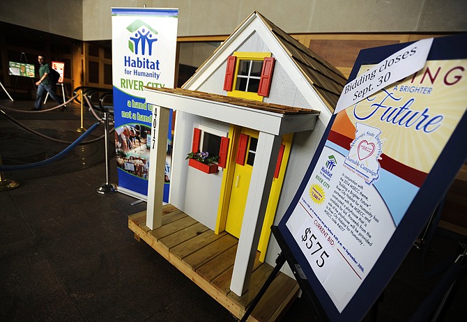 A newly constructed playhouse sits on display on the first floor of the Truman Building as workers head for the doors to begin the weekend at the close of business on Friday. 