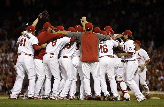 Members of the St. Louis Cardinals celebrate after the Cardinals' 7-0 win over the Chicago Cubs to clinch the NL Central title Friday, Sept. 27, 2013, in St. Louis. 