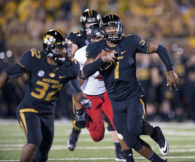 Missouri quarterback James Franklin, right, runs behind the block of teammate Russell Hansbrough, left, as he scores a touchdown during the fourth quarter of an NCAA college football game Saturday, Sept. 28, 2013, in Columbia, Mo. 