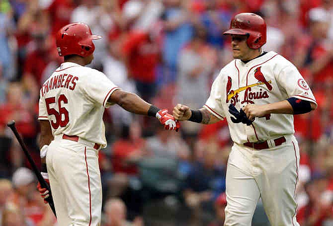 St. Louis Cardinals' Yadier Molina, right, is congratulated by teammate Adron Chambers after scoring on a ground-rule double by Pete Kozma during the third inning of a baseball game against the Chicago Cubs, Saturday, Sept. 28, 2013, in St. Louis. 