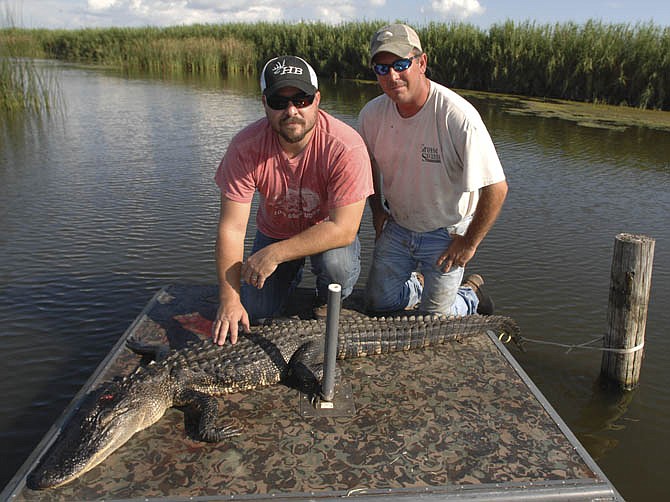 Brandon Butler (left) and Doug Miller pose with a Louisiana alligator. Â 