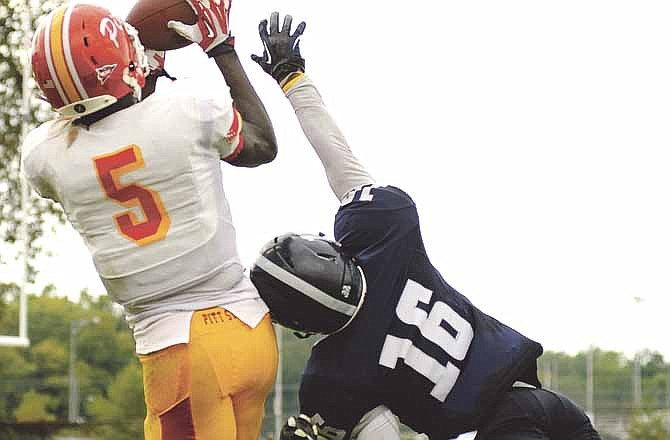 Pittsburg State wide receiver John Brown hauls in one of his four touchdown catches, just out of reach of Lincoln defensive back Brian Smith, late in the second quarter of Saturday's game at Dwight T. Reed Stadium.