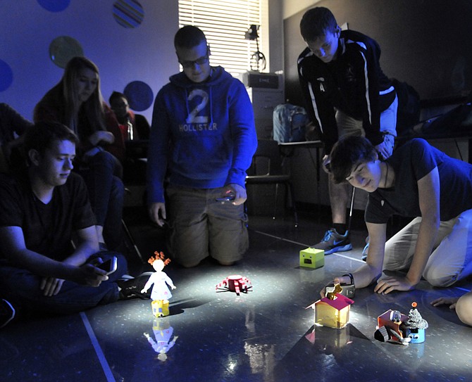 Students in Jana Forck's AP Calculus AB-II class use cellphone lights to activate the robots they created in a group project. 