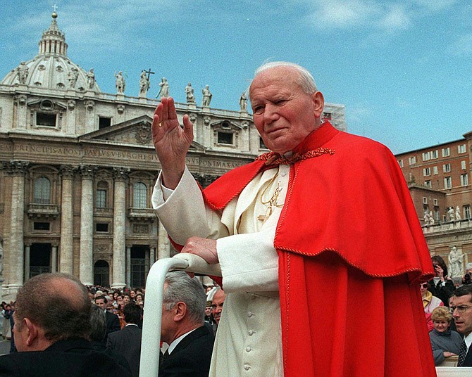 Pope John Paul II waves to faithful as he crosses St. Peter's square in April 1997 at the Vatican. Popes John Paul II and John XXIII will be declared saints on April 27, 2014. Pope Francis announced the date Monday during a meeting with cardinals inside the Apostolic Palace.