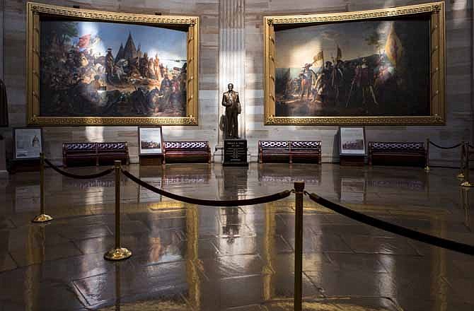 Normally filled with visitors and tourists, the empty Rotunda at the U.S. Capitol is seen in Washington, Tuesday, Oct. 1, 2013, after officials suspended all organized tours of the Capitol and the Capitol Visitors Center as part of the government shutdown. A statue of President Gerald R. Ford at center is illuminated amid large paintings illustrating the history of the United States.