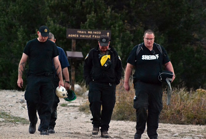 Chaffee County sheriff's deputies walk out the Agnes Vaille Falls trail shortly after leaving the scene of a rock slide that killed five people Monday in Colorado.