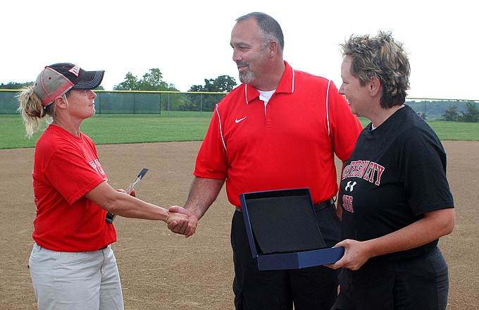 Jefferson City softball coach Lisa Dey (left)  receives a trophy from Jefferson City activities director Mark Caballero and assistant principal Karen Brickey on Wednesday at the American Legion Sports Complex in honor of the 400th win of her coaching career at the school. 