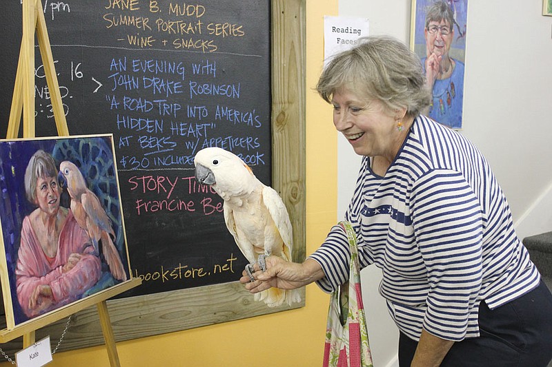 Kate Bayer and her 23-year-old Moluccan cockatoo, Kalki, see their portrait for the first time on display at Well Read for the Brick District's First Thursday event.