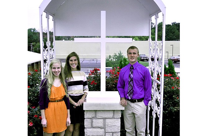 Helias Catholic High School students Laura Vanderfeltz, Kylie Mulholland and Cole Vanderfeltz, grandchildren of Leon and Rita Mae Vanderfeltz, stand near the grotto that once held a statue of Jesus and the Virgin Mary, until vandals toppled it last April. 