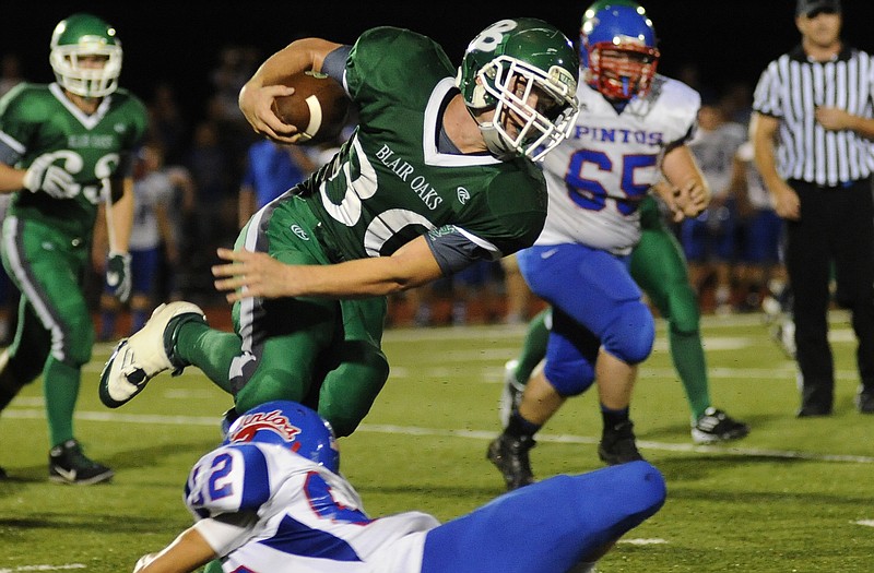 Blair Oaks running back Caleb Bischoff runs past California's Allan Burger on Friday night at the Falcon Athletic Complex.
