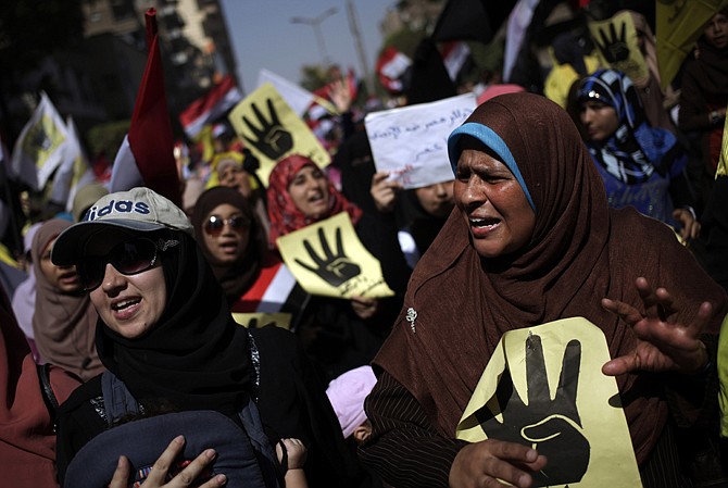 Supporters of Egypt's ousted President Mohammed Morsi chant slogans Friday in Cairo, Egypt, against Egyptian Defense Minister Gen. Abdel-Fattah el-Sissi and hold placards showing an open palm with four raised fingers, which has become a symbol of the Rabaah al-Adawiya mosque, where Morsi supporters had held a sit-in for weeks that was violently dispersed in August.