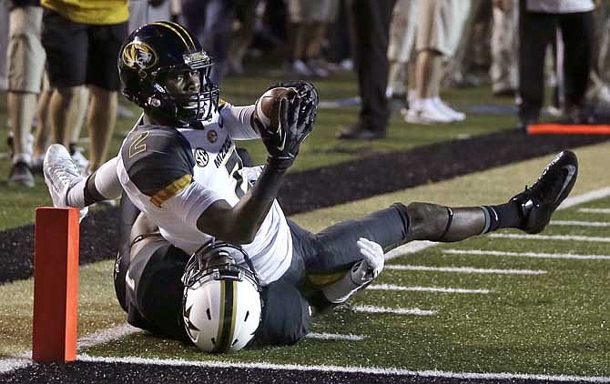 Missouri wide receiver L'Damian Washington, top, reaches across the goal line for a touchdown as he is brought down by Vanderbilt safety Kenny Ladler, bottom, in the first quarter of an NCAA college football game on Saturday, Oct. 5, 2013, in Nashville, Tenn. Washington scored on a 26-yard pass play. 