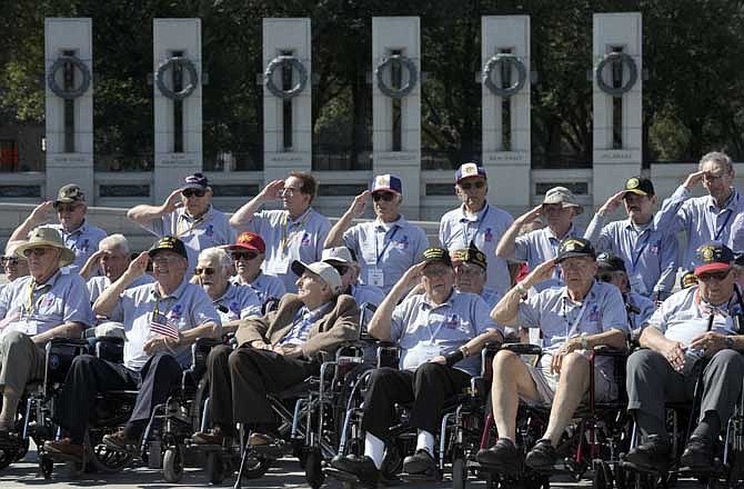 World War II veterans from the Chicago-area salute as they visit the World War II Memorial in Washington, Wednesday, Oct. 2, 2013. The group came to Washington on an honor flight despite the shutdown of the federal government. 