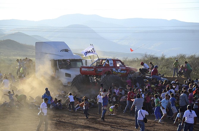 People run as an out of control monster truck plows through a crowd of spectators Saturday at a Mexican air show in Chihuahua, Mexico.