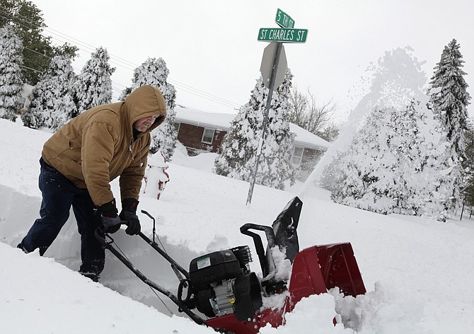 Don Stritecky clears the sidewalk Saturday in front of his home with a snow blower in Rapid City, S.D. The area was a soggy mess Sunday after the record-setting snowfall began melting.