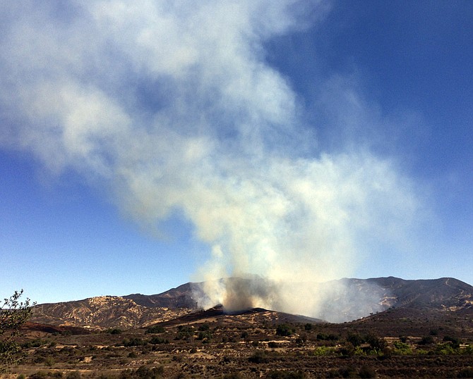 Firefighters are battling a vegetation fire that spread after a large pile of mulch began burning Sunday morning at a nursery in the Baker Canyon area of Silverado, in Orange County, Calif., a fire captain said.